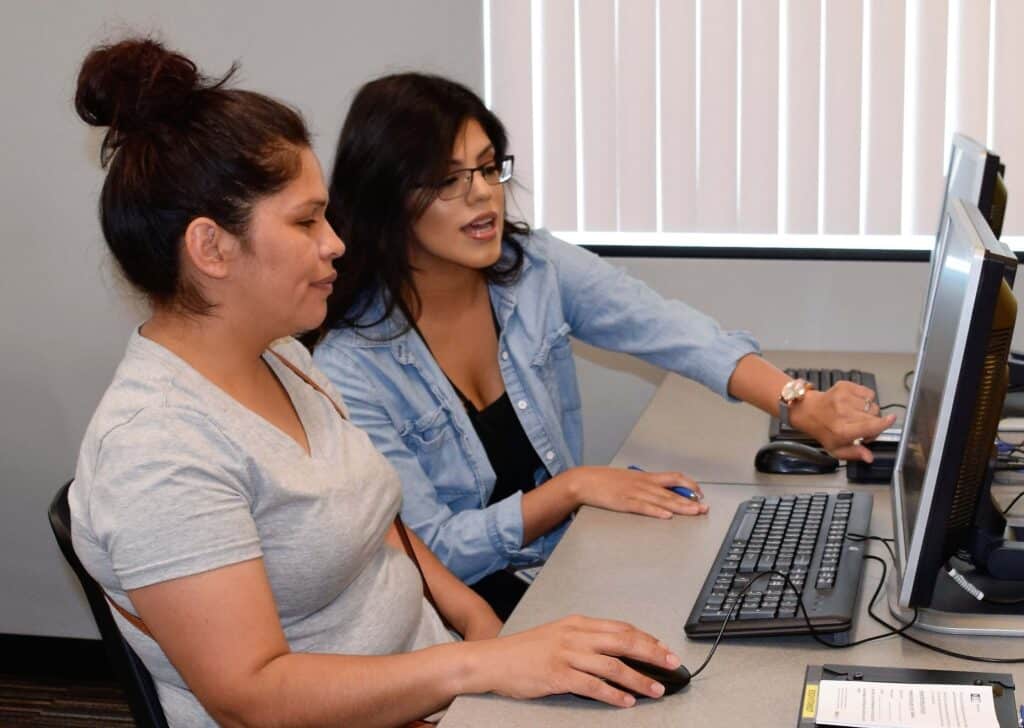 SkillSource teacher helping an adult student in a computer lab.