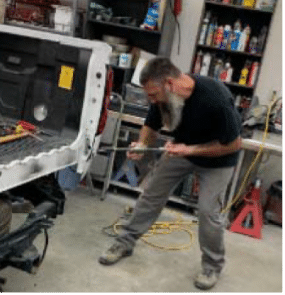 Image of SkillSource client Rosco working on a truck in an auto body shop.