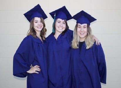Three young women in graduation cap and gowns.