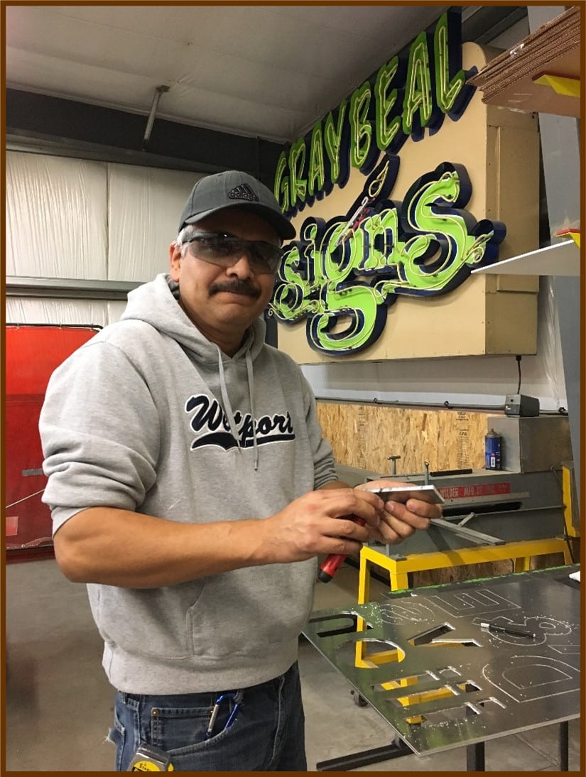 SkillSource client Marcos at his internship at a sign company.