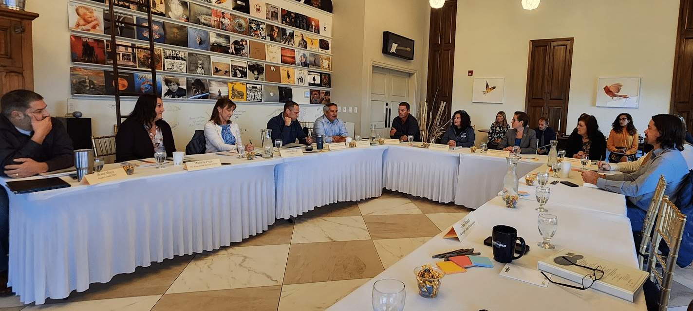 The SkillSource Regional Workforce Board seated at a large U-shaped table in a brightly-decorated conference room at Cave B Wineries.