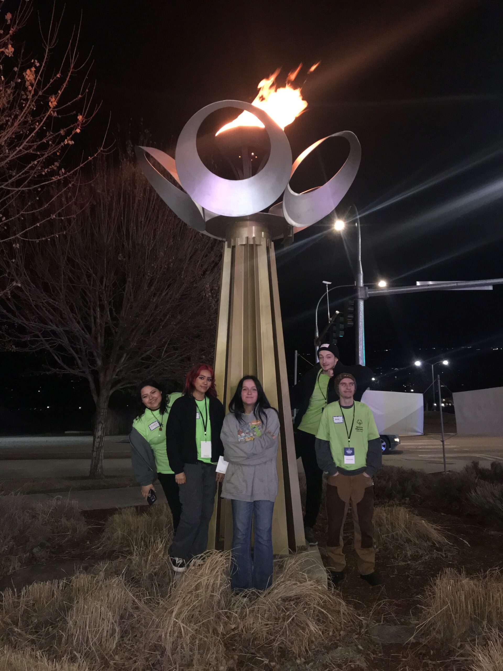 SkillSource students pose by the Special Olympics torch shortly before seating the athletes at the Opening Ceremony