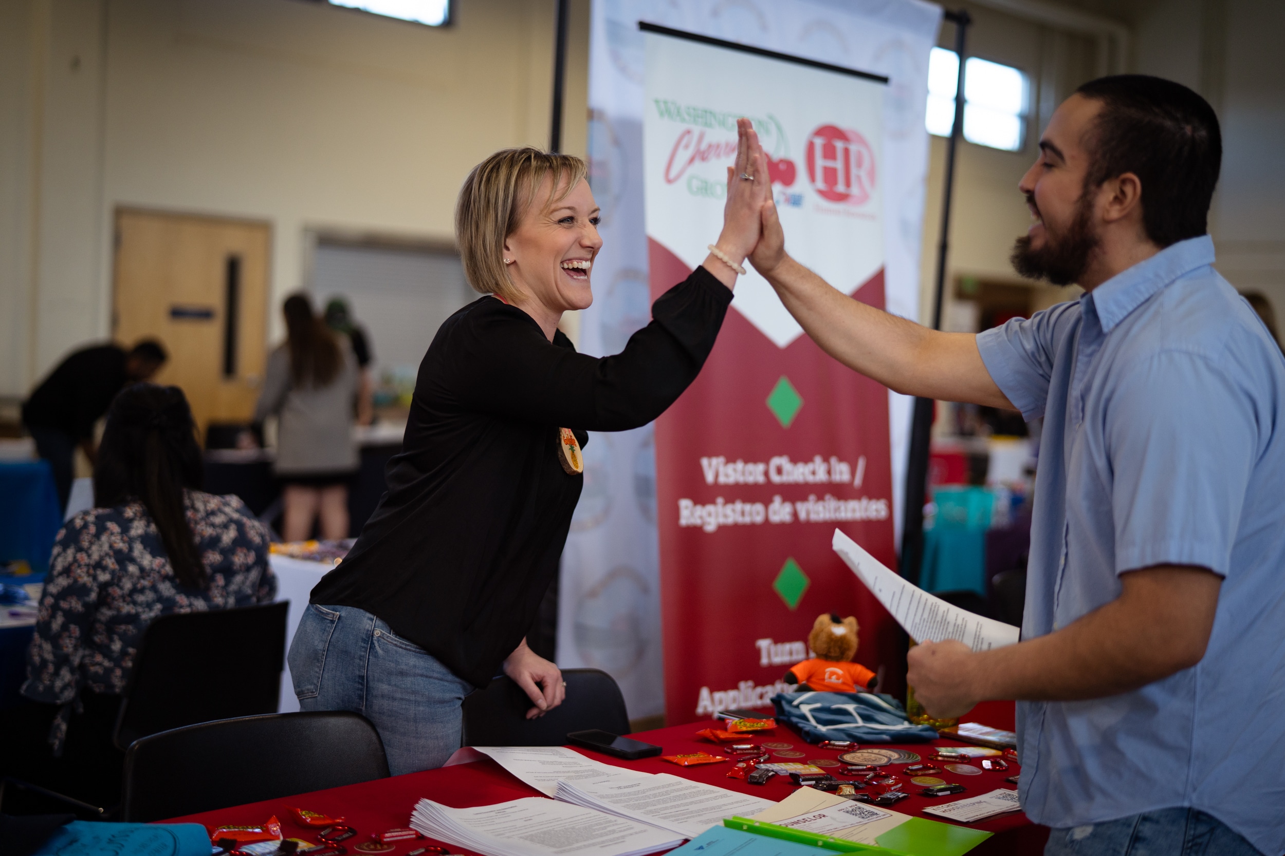 Two people high five over a table.