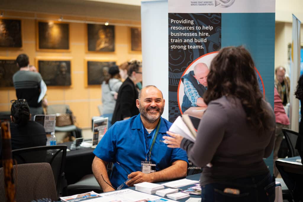 SkillSource member smiling while explaining services to a young woman
