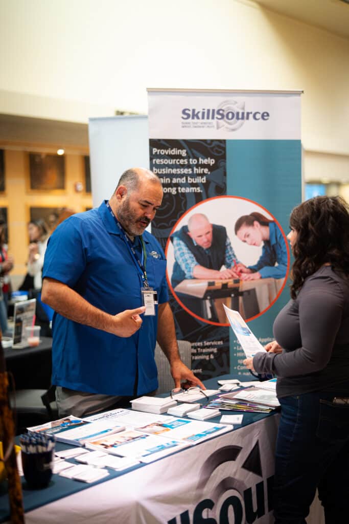 SkillSource member informing a woman about SkillSource