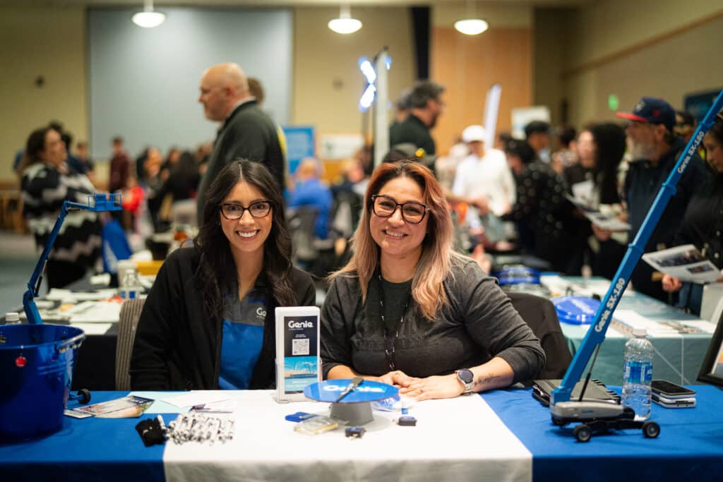 Two smiling woman sitting behind a booth at Big Bend Community College&#039;s Job Fair