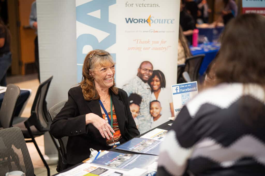 A woman smiling while discussing her services at Big Bend Community College&#039;s Job Fair