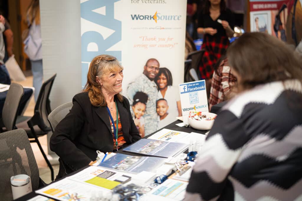 A woman smiling while discussing her services at Big Bend Community College&#039;s Job Fair