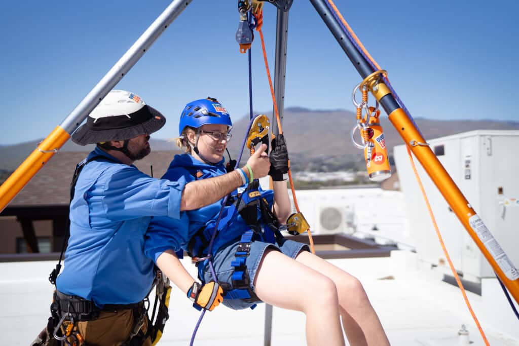 Woman placed on the seat ready to rappel off the Residence Inn Building
