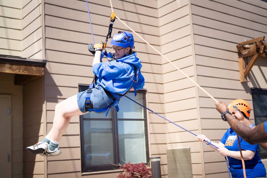 A woman close to landing after rappelling off the Residence Inn Building