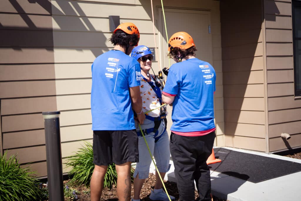 Woman with two Over the Edge members after landing