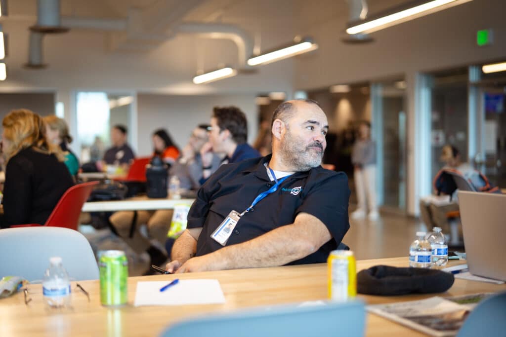 A SkillSource member sitting at a table looking behind him