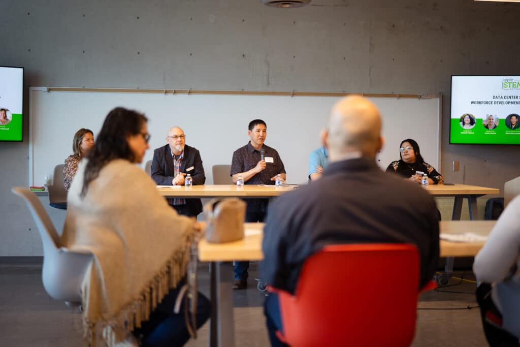 A group of 5 individuals talking to a group of people at Big Bend Community College. Man in the middle is holding up a mic